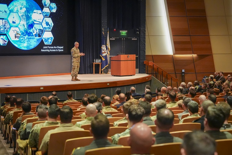 A man speaking in an auditorium of people